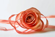 A rose made of pink ribbon on a white background.