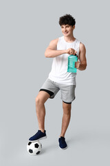 Poster - Sporty guy with bottle of water and football ball on white background