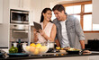 Couple, cooking and tablet for recipe, kitchen and home with online, cheerful and making dinner. Food, digital and together with internet, family and nutrition while streaming, laughing and learn