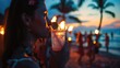 Under the midnight sky, a woman is enjoying a refreshing drink of water through a straw on the beach. The sound of music adds to the fun atmosphere during this latenight beach event AIG50