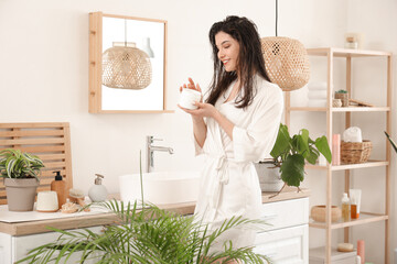 Canvas Print - Beautiful young happy woman with jar of hair mask in bathroom at home