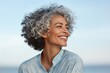 © MediaRaw - A woman with a short, curly, gray hair is smiling and looking at the camera