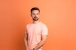 © MediaRaw - A man in a pink shirt stands in front of a bright orange wall