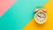 Vibrant pink alarm clock on a blue and yellow background