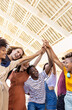 © Xavier Lorenzo - Vertical shot of group of multiracial teenager friends stacking hands outdoors. Community and teamwork concept with happy diverse united young people with hands in stack