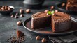 Moist chocolate cake with hazelnuts on dark plate, elegant dessert presentation