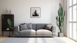 A lone cactus stands in a pot next to a gray couch in a sparsely decorated room. AIG51A.