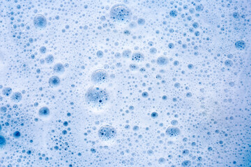 Wall Mural - Detergent foam bubble on water. Blue background, Soap sud