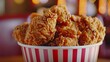 Close-up of a bucket filled with a variety of crispy fried chicken pieces, each one seasoned to perfection