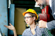 © Stella - ฺฺBeautiful woman industrial engineer worker wears helmet and safety glasses using computer to discuss with businessman, people work at manufacturing plant industry factory, boss and secretary talking