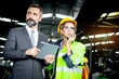 © Stella - Beautiful woman industrial engineer worker wearing safely helmet and protective clothing, holding tablet and discussing with her senior businessman manager, at heavy industry manufacturing factory