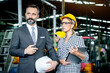 © Stella - Young beautiful woman industrial engineer worker with helmet and safety glasses using laptop computer during discussing with senior businessman manager, people work at manufacturing industry factory