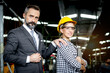 © Stella - Portrait of senior businessman manager with beautiful woman industrial engineer worker with helmet and safety glasses holding laptop computer at manufacturing industry factory. People at workplace.