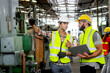 © Stella - Industrial foreman and worker with helmet and safety vest using laptop computer during discussing together at manufacturing industry factory. Engineer inspecting workplace and checking process.