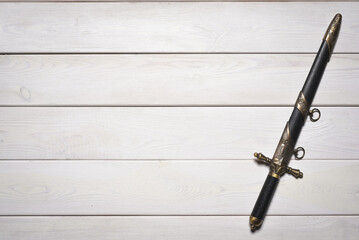 Wall Mural - Vintage retro style dagger sword on the white wooden table background with copy space. Pirate table.