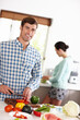 © peopleimages.com - Man, smile and portrait in kitchen with vegetable and girlfriend for food and cooking together healthy meal for detox. Boyfriend or young person and happy in house with ingredients for nutrition