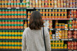© peopleimages.com - Woman, grocery and canned food in supermarket for economy, purchase and products for nutrition. Female person, retail and shelf inside store with baked beans for shopping, vegetables and diet