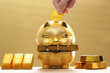 Saving gold, Golden piggy banks and have gold bars with stack of coins money on yellow background, Business investment and Saving money for prepare in