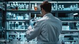 Fototapeta Uliczki - A unrecognizable man wearing a lab coat and conducting a scientific experiment in a laboratory illustrating research and innovation,
