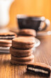 Close-Up View of Chocolate-Coated Sandwich Cookies on wooden table.