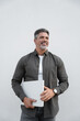 © Stock 4 You - Vertical portrait of successful middle age freelance entrepreneur, latin hispanic businessman holding laptop computer. Mature smiling man user with wireless pc for business. Isolated, white background