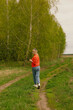 © artem - a girl walking along a dirt road along the forest, filmed on a cloudy spring day in the village of Shanary in Chuvashia