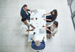 From above, business people or discussion in office meeting for partnership, collaboration or corporate deal. Workplace, boardroom or team with documents for agreement, project or working