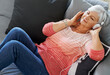 Woman, senior and headphones on couch for relax, retirement and podcast in house. Happiness, wellness and peace on sofa in living room for self care, online and streaming for mindfulness and zen