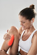 Fitness, woman and leg pain in studio with injury after running, practice or workout on gray background. Sport, exercise and person with red overlay for inflammation, calf strain or muscle tension