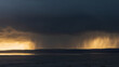 Beautiful moody storm skies over ocean landscape with distant heavy rainfall