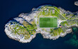 The Henningsvaer football Stadion on an island in Lofoten, Norway. Iconic soccerfield on an island in the atlantic ocean. Aerial top down drone view.