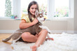 Smiling girl and her Siberian Husky puppy on carpet at home. High quality photo