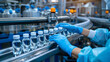 Pharmaceutical scientist wearing sterile gloves inspects medical vials on a production line conveyor belt in a drug manufacturing facility.