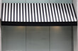 A black and white striped awning over a window