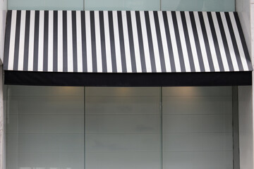 Sticker - A black and white striped awning over a window