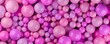 Heap of different sized pink colored spheres or balls, color, education or playing concept background