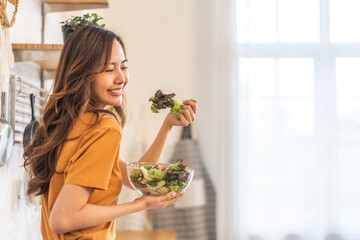 Wall Mural - Portrait of beauty body slim healthy asian woman eating vegan food healthy with fresh vegetable salad in kitchen at home.diet, vegetarian, fruit, wellness, health, green food.Fitness and healthy food