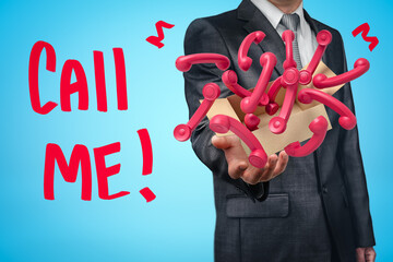 Wall Mural - businessman holding cardboard box filled with pink retro telephone receivers