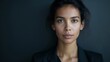 © Oksana Smyshliaeva - Confident Businesswoman with a Serious Expression on Dark Background