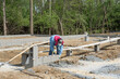 Migrant Worker Laying Cement Block Building Foundation