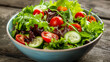 fresh salad in a blue bowl. It features a variety of vegetables and greens, such as sliced tomatoes and lettuce