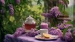 Lilac flowers, cup of coffee and teapot on table outdoors