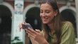 © Andrii Nekrasov - Woman with brown hair, dressed in an olive green sweater, using mobile phone app texting sms on social media
