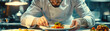 © panyawatt - Illustrate the precision and focus of a chef plating a dish