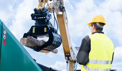 Poster - Worker with digital tablet controls process of loading timber
