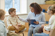 © Seventyfour - Side view portrait of young female psychologist comforting boy in support group for children and teenagers