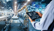 © panuwat - Smart industry control concept.Hands holding tablet on blurred automation machine as background