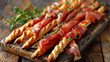 
Bunch of traditional italian Grissini breadsticks wrapped parma ham, prosciutto with fresh herbs on a wooden board, close up view
