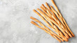 Italian grissini or salted breadsticks on a light stone background