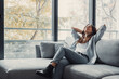 © Daniel - Relaxed serene pretty young woman feel fatigue lounge on comfortable sofa hands behind head rest at home, happy calm lady dream enjoy wellbeing breathing fresh air in cozy home modern living room.